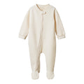 Cream organic cotton waffle texture baby onesie with a zipper and feet on a white background