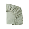 Green and cream striped organic cotton cot sheet with elasticated edges on a white background