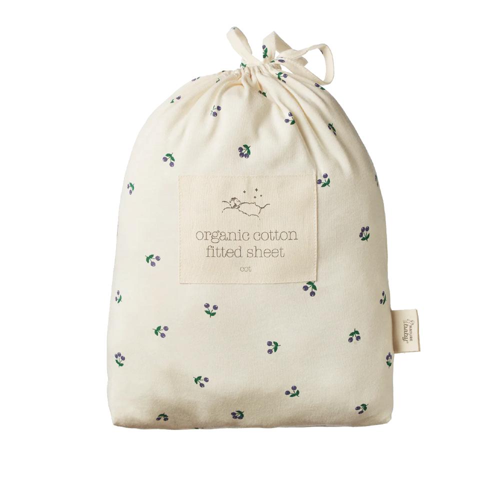 Nature Baby Cream Drawstring bag with organic cotton fitted sheet label and berry pattern on a white background