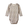 cream and purple floral merino baby bodysuit with long sleeves and envelope neck on a white background