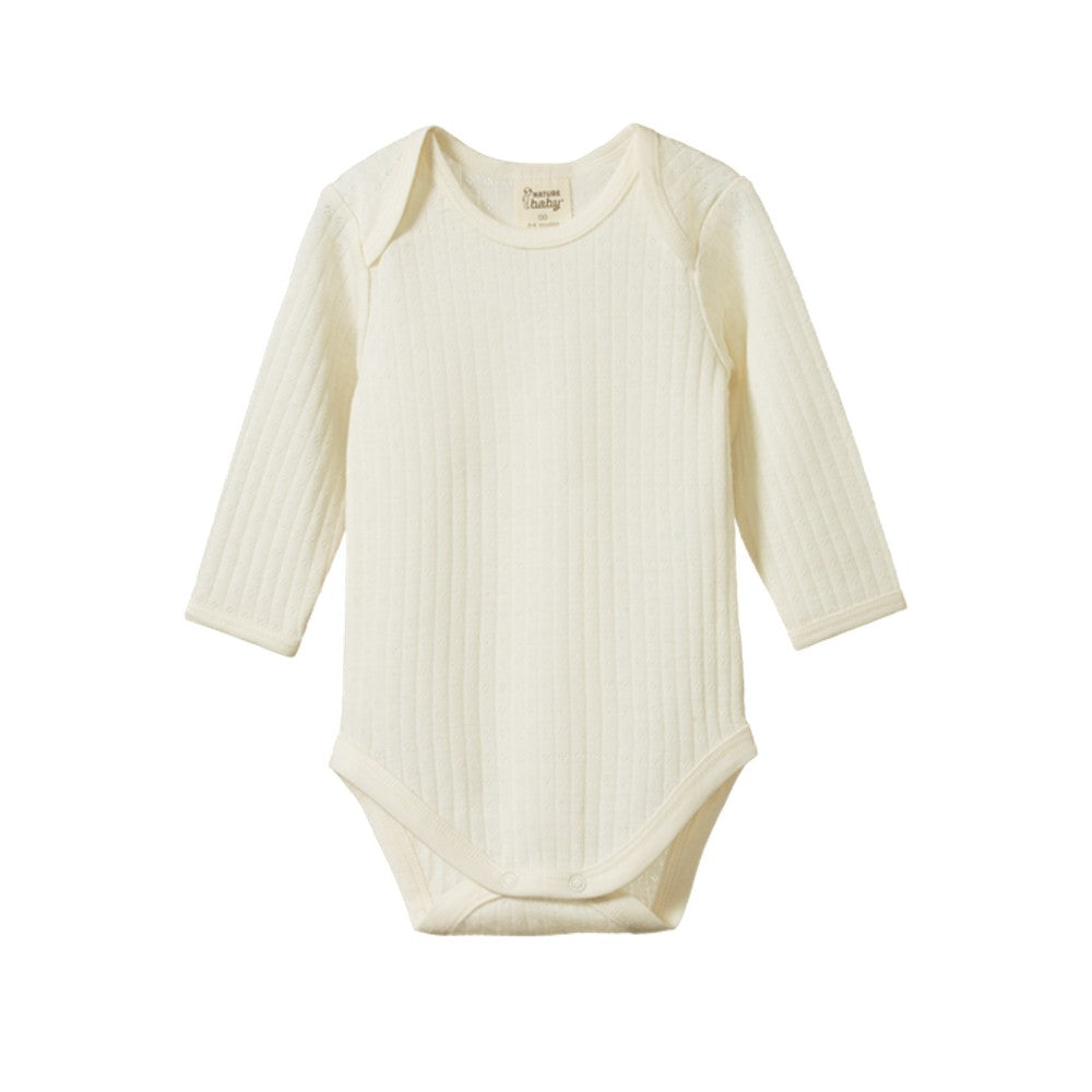Cream merino pointelle baby bodysuit with long sleeves on a white background