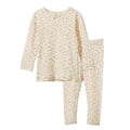 A two-piece children's pajama set featuring a long-sleeve top and matching leggings, both in a warm cream color with a delicate, all-over small floral print in muted pink and green.