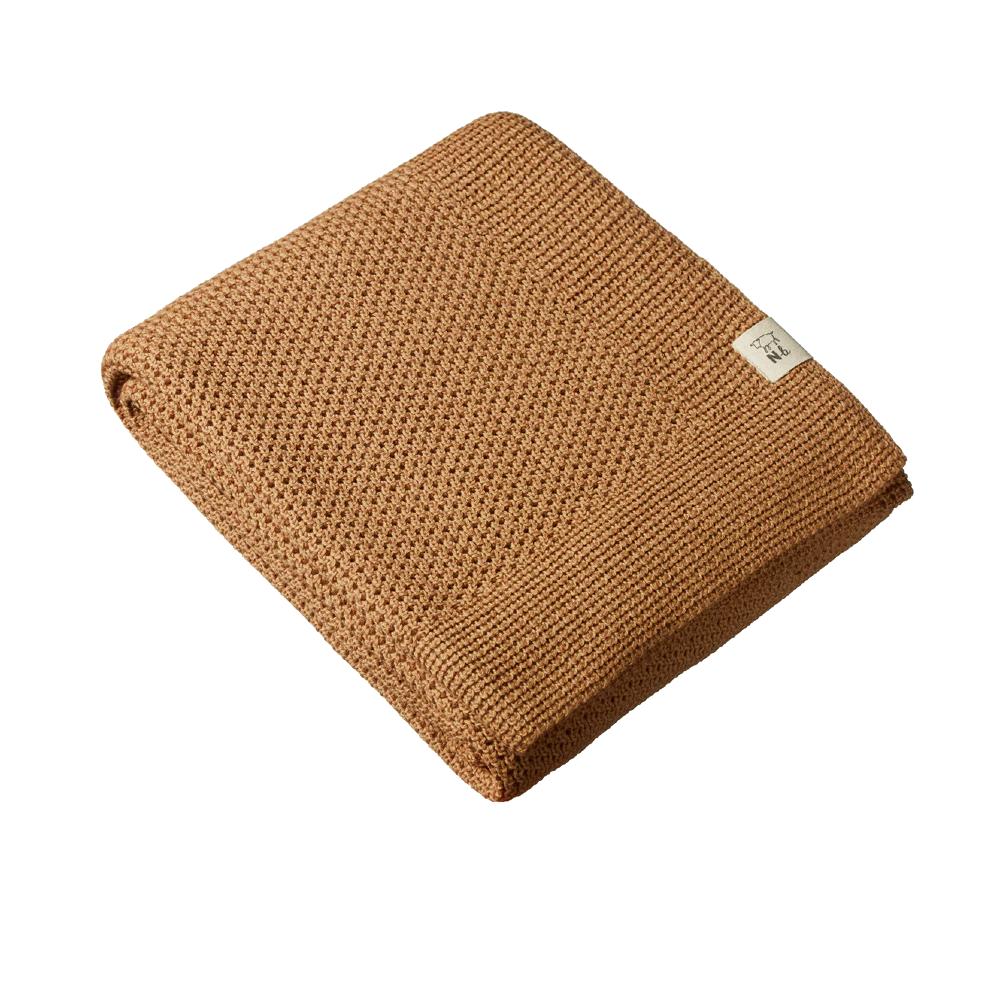 Caramel brown woolen knitted blanket with a brand label on a white background