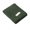 Forest Green merino wool knitted blanket with a white label on a white background