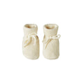 Pair of cream-colored merino knitted baby booties from Nature Baby on a white background