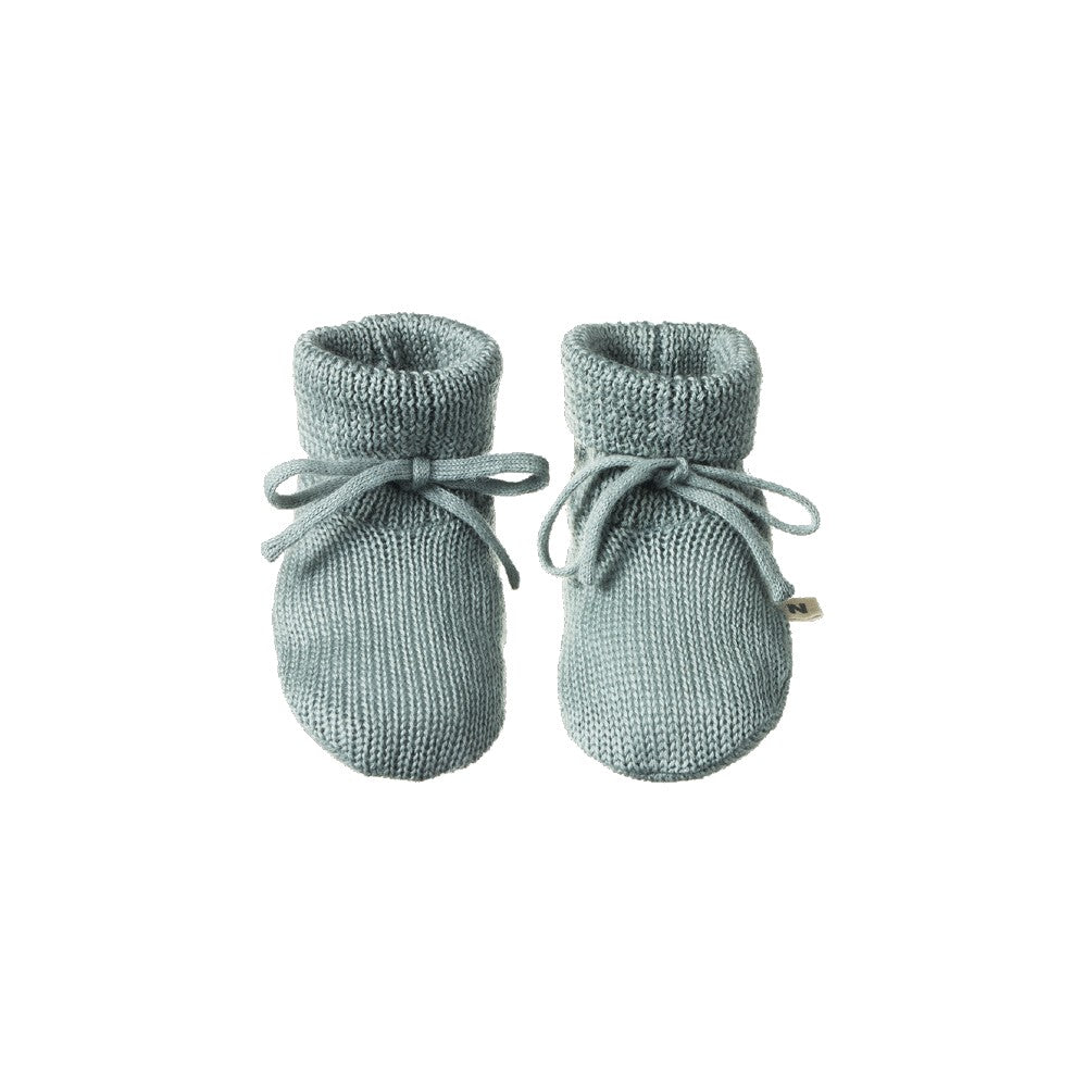 Pair of sage merino knitted baby booties on a white background