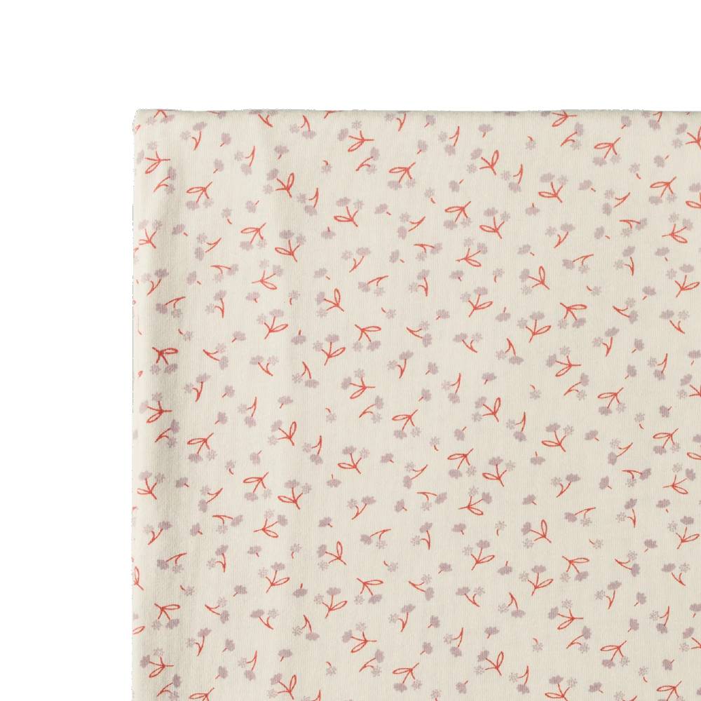 A close-up of a swaddle wrap with a delicate repeating floral pattern on a warm off-white background.