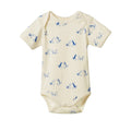 A short-sleeve baby bodysuit in cream with a blue line-art print of dogs, shown flat against a white background.