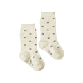 Pair of cotton cream socks with grey polka dots on a white background