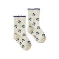 Pair of cream socks with purple berry pattern and purple trim on a white background