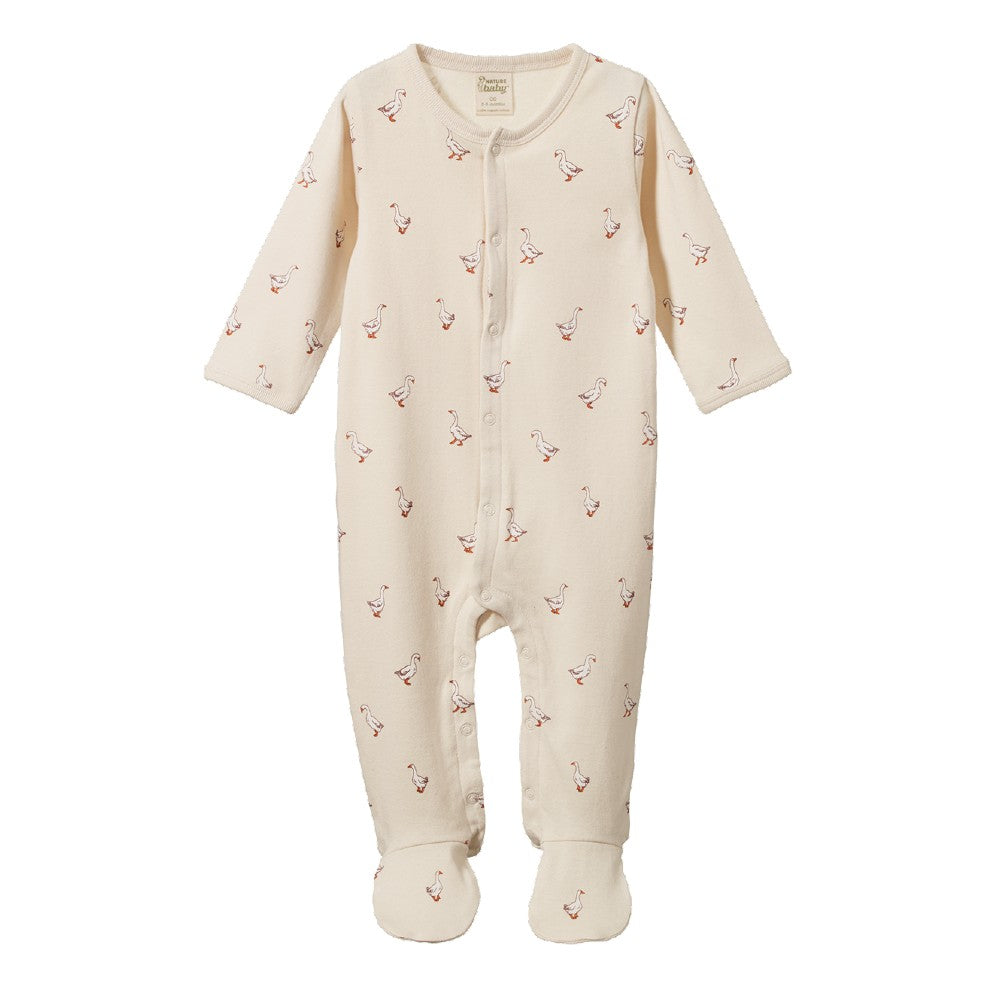 A cream-colored baby footed sleep onesie with a small red and white goose pattern, featuring a snap-button front and long sleeves and legs.