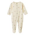 A cream-colored baby footed onesie with a small brown drums print, featuring a snap-button front and long sleeves, shown against a plain white background.