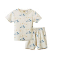 A two-piece pajama set featuring a short-sleeve top and matching shorts in cream with a blue dog and yellow star pattern, displayed on a clean white background.