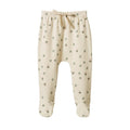 Cream coloured baby footed leggings with green and pink clover pattern on a white background