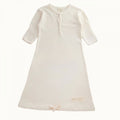 Cream coloured cotton jersey baby gown with sleeves on a white background