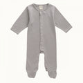 Grey and white striped footed baby onesie with snap domes on a white background