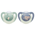 Two NUK baby pacifiers on a white background, one in sage green with a sleeping hippo design and one in dusty blue with a sleeping koala design.