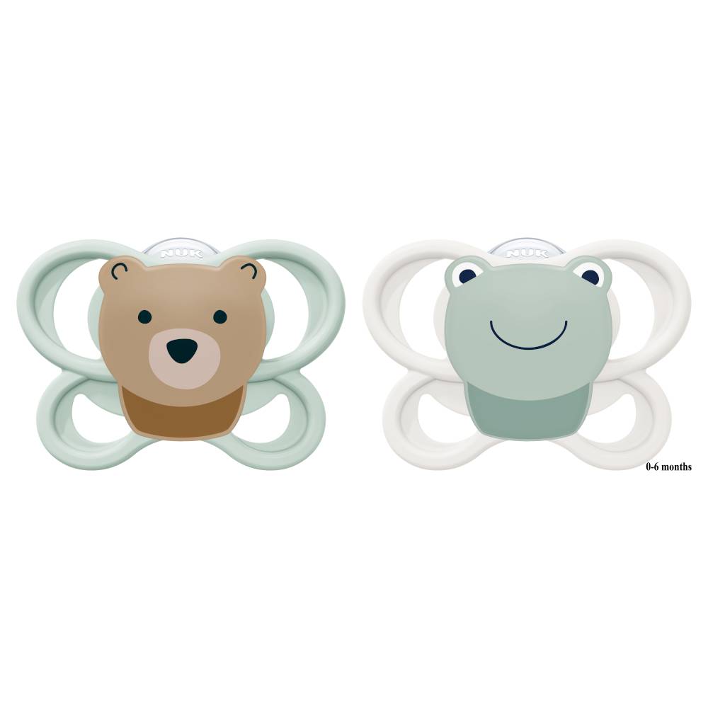 Two baby pacifiers on a white background: one with a bear face in tan and brown with a mint green shield, and one with a smiling frog face in pale green with a white shield. Small text reads 6-4 months.