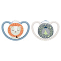 Two baby pacifiers on a plain white background. The left pacifier has a light blue shield with a cartoon lion face in orange, white, and brown.