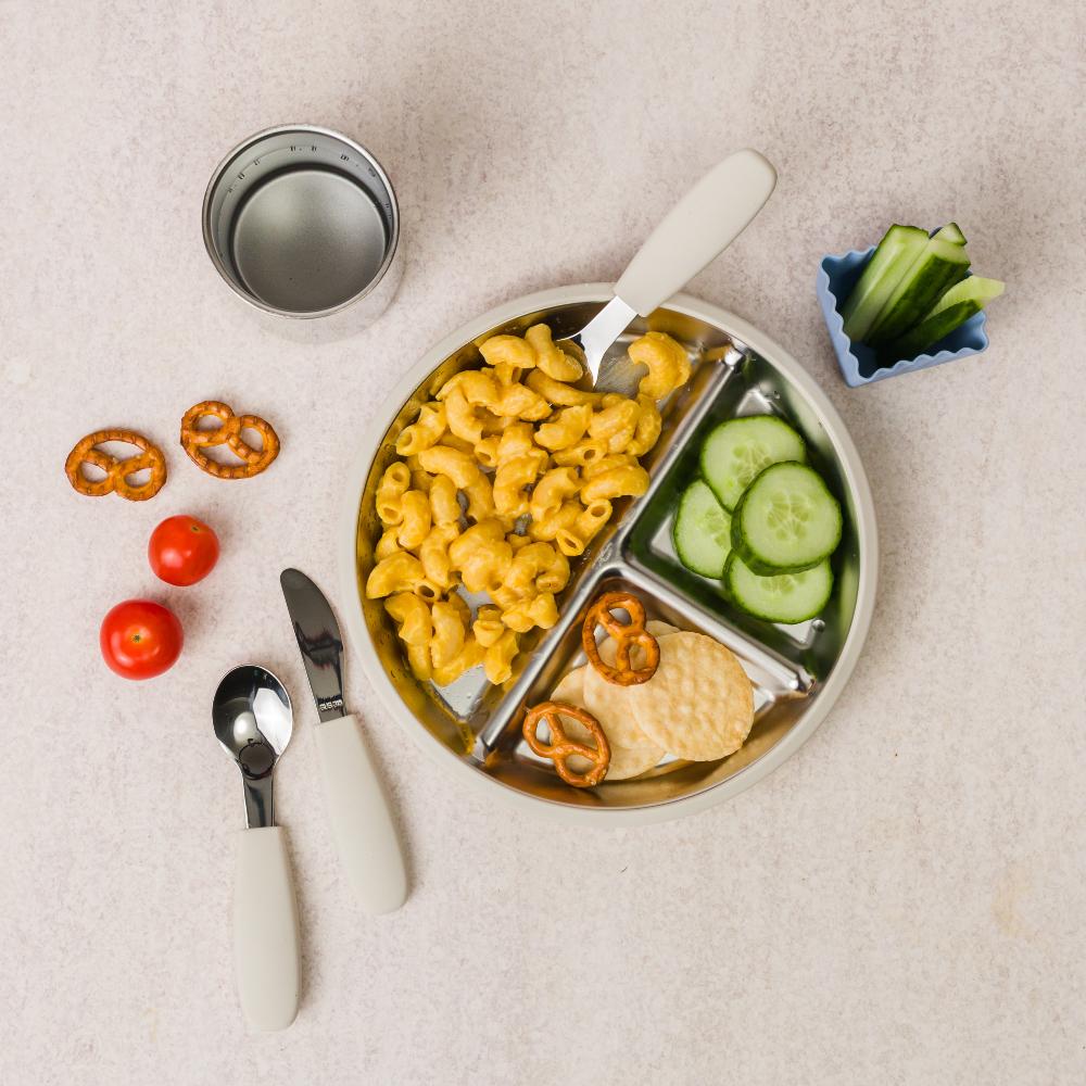 Divided Stainless Steel plate with pasta, cucumbers and crackers. 