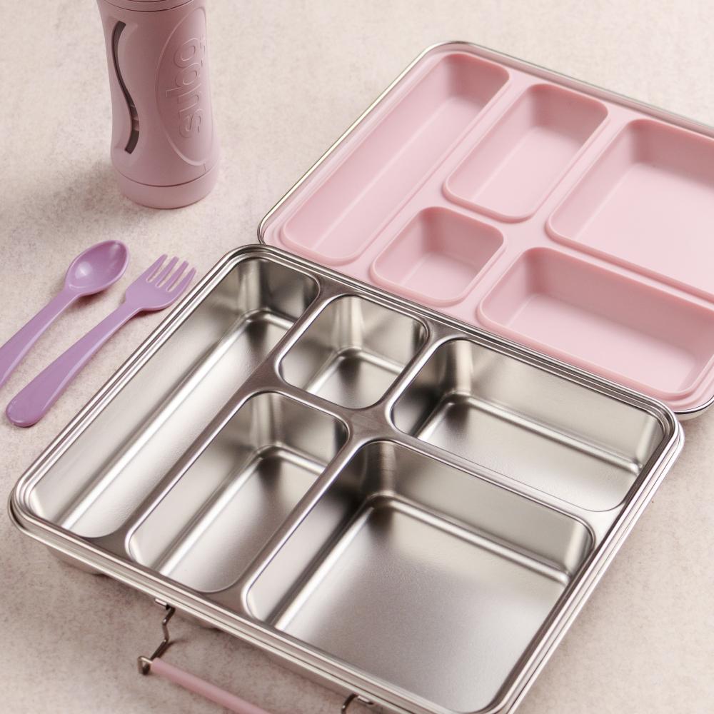 Stainless steel and pink divided lunch box with purple utensils on a beige surface