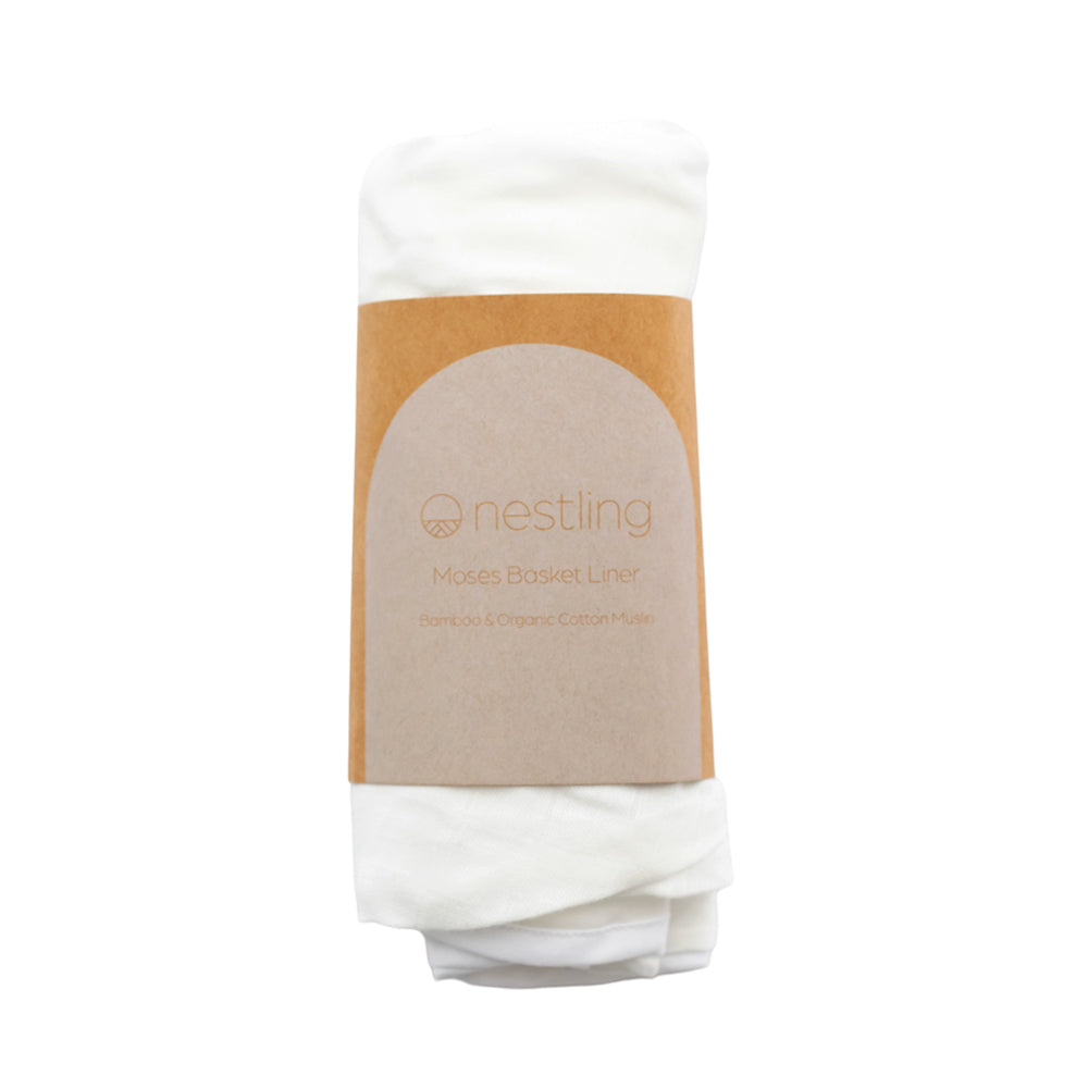 White moses basket liner with a brown label on a white background