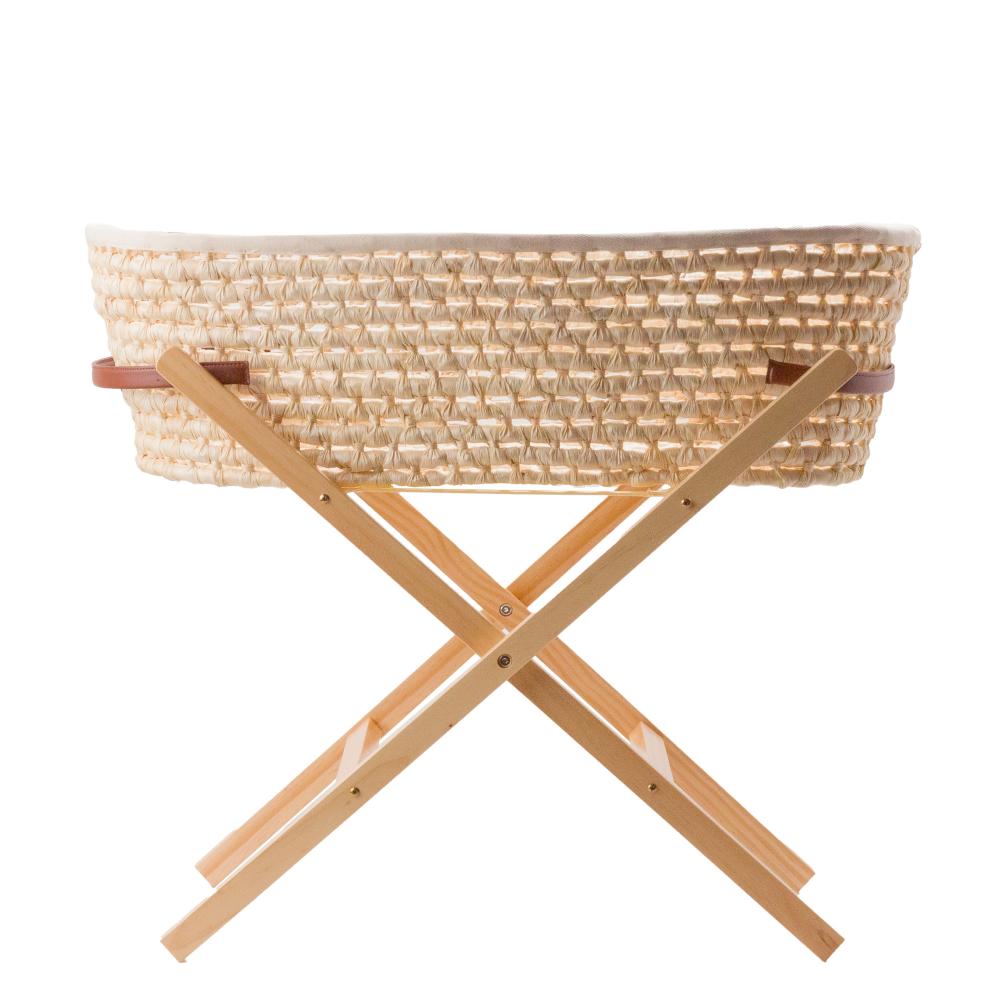 Wicker baby Moses basket with wooden stand on a white background