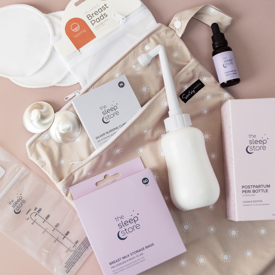 Collection of breastfeeding and postpartum care products on a patterned background