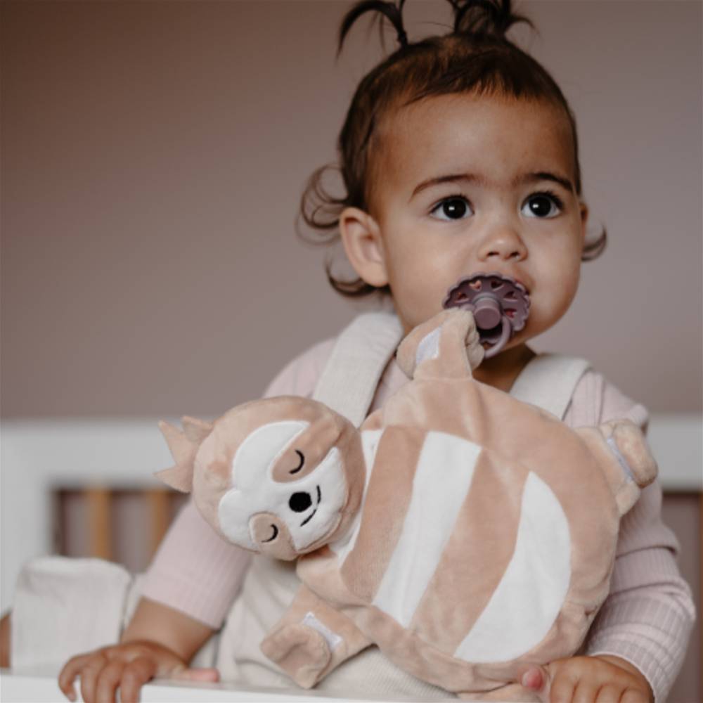 Baby using brown sloth Sleepytot comforter.