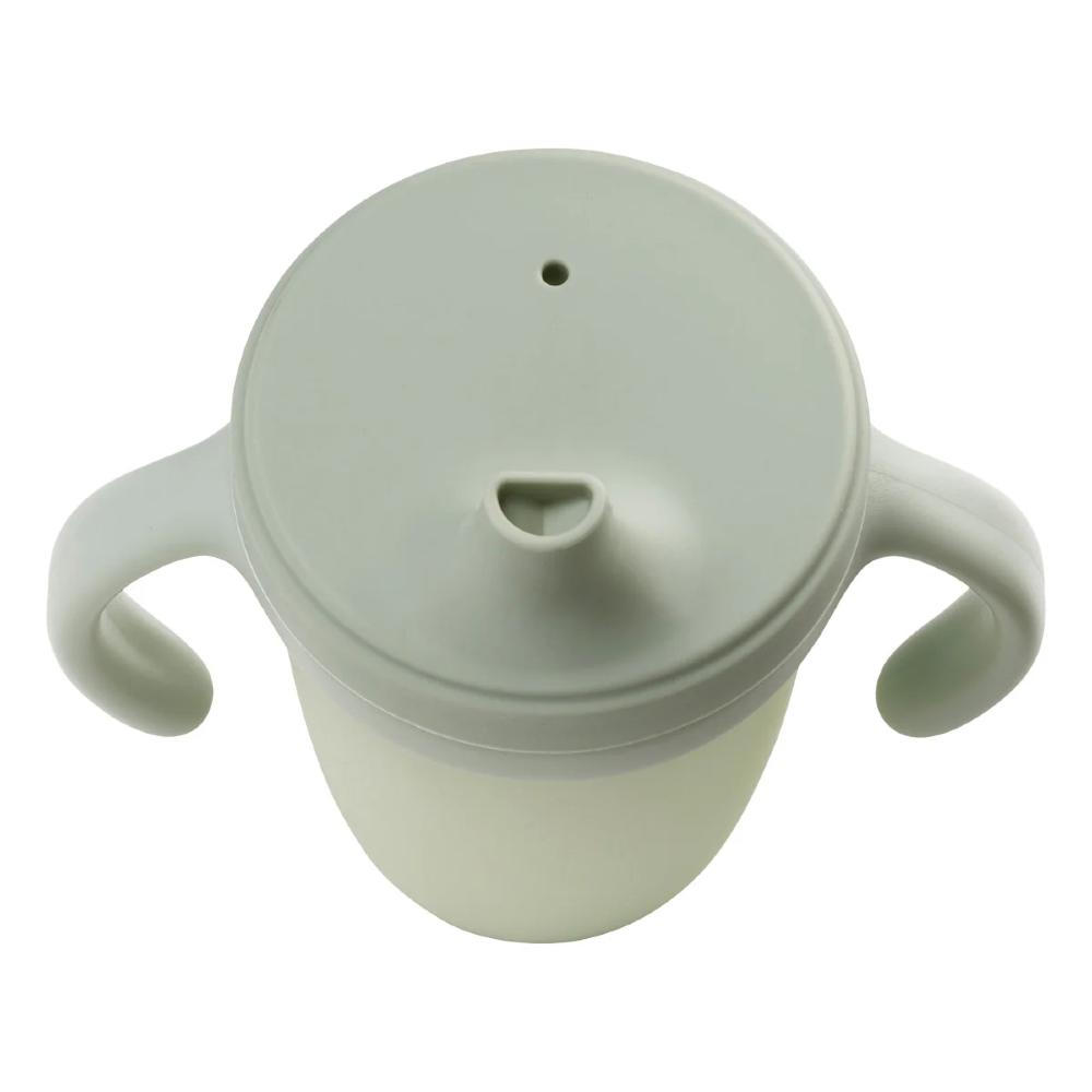 A light sage green plastic baby cup with a matching lid, side handles, and a small nipple spout, shown on a solid white background.
