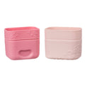 Two pink silicone snack containers with embossed designs on a white background