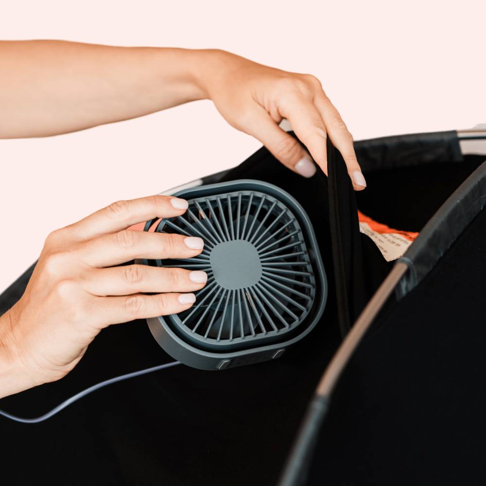 Person inserting a Slumberpod Fan into a Slumberpod with a white background