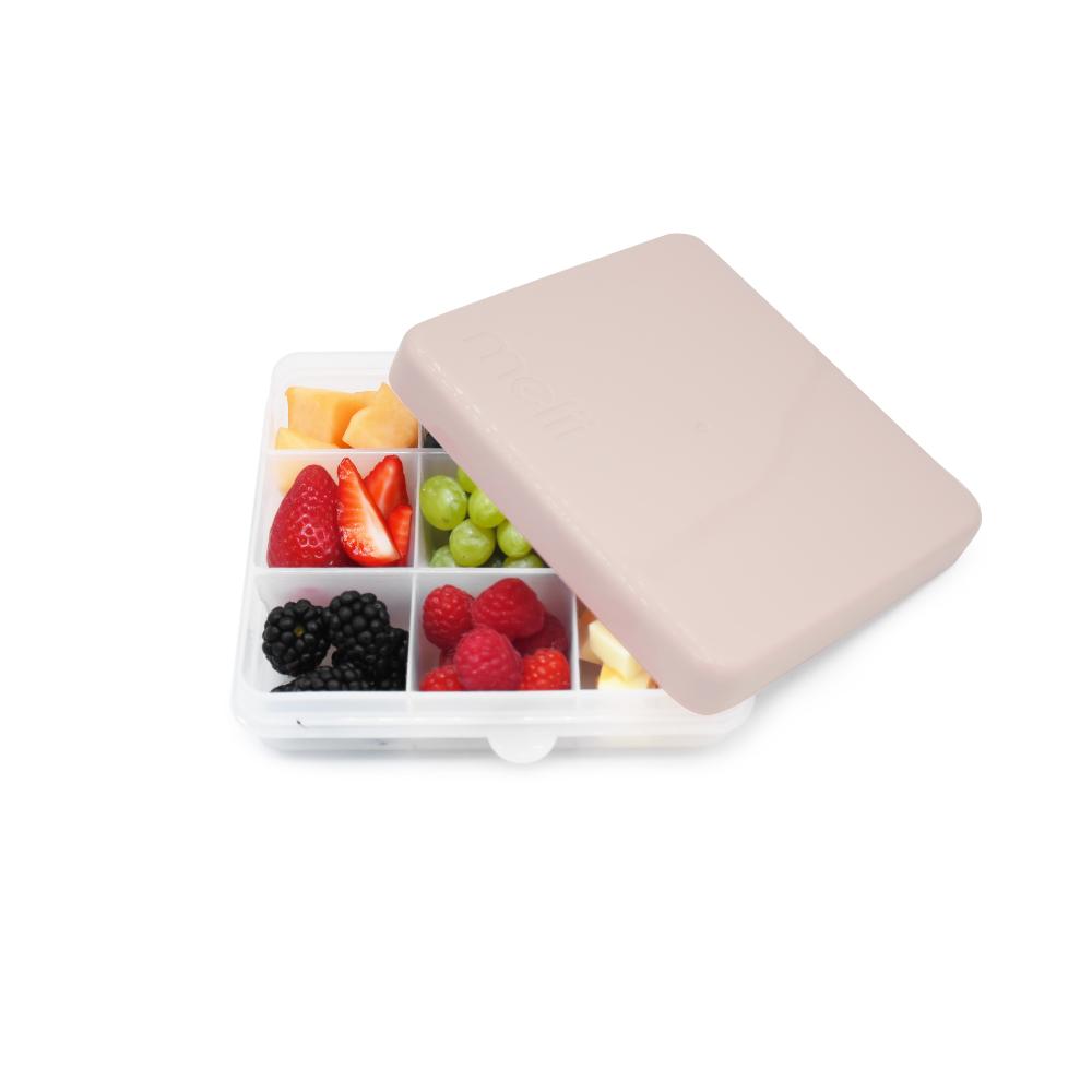 Oat Snackle box with assorted fruits including strawberries, grapes, blackberries, and raspberries on a white background.