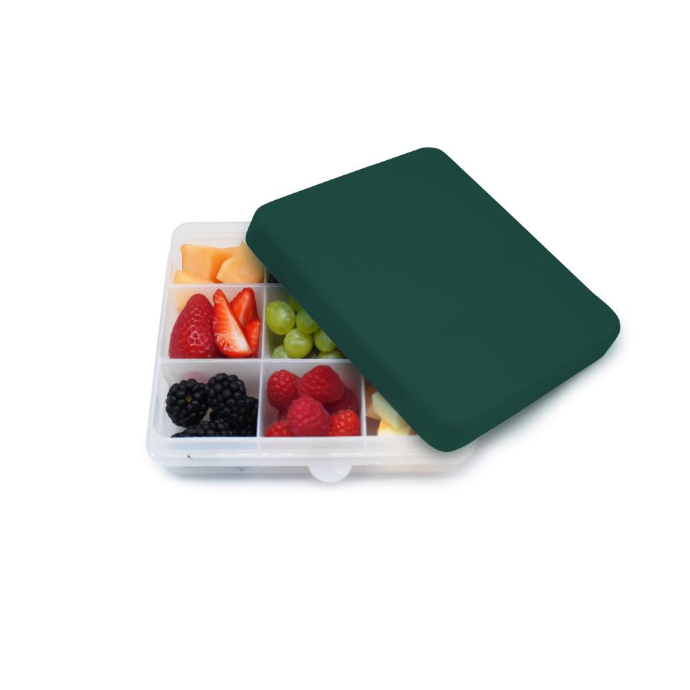 Fruit compartmentalized Melii Square snackle container with a green lid on a white background