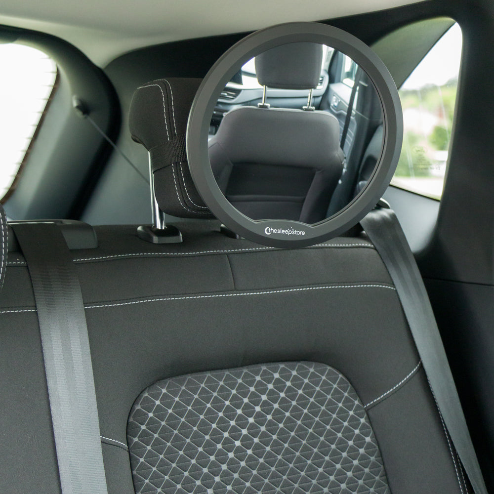 Car interior with a round mirror mounted on the back of a seat