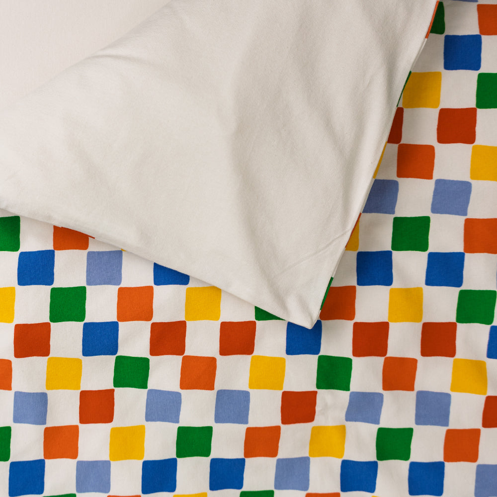 Cotton duvet cover in a bright colour check print on one side and solid cream colour on the reverse side.