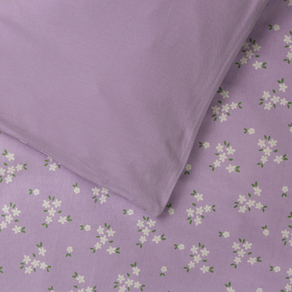 Cotton duvet cover with a lilac base and all over floral print on one side and solid lilac on the other side. 