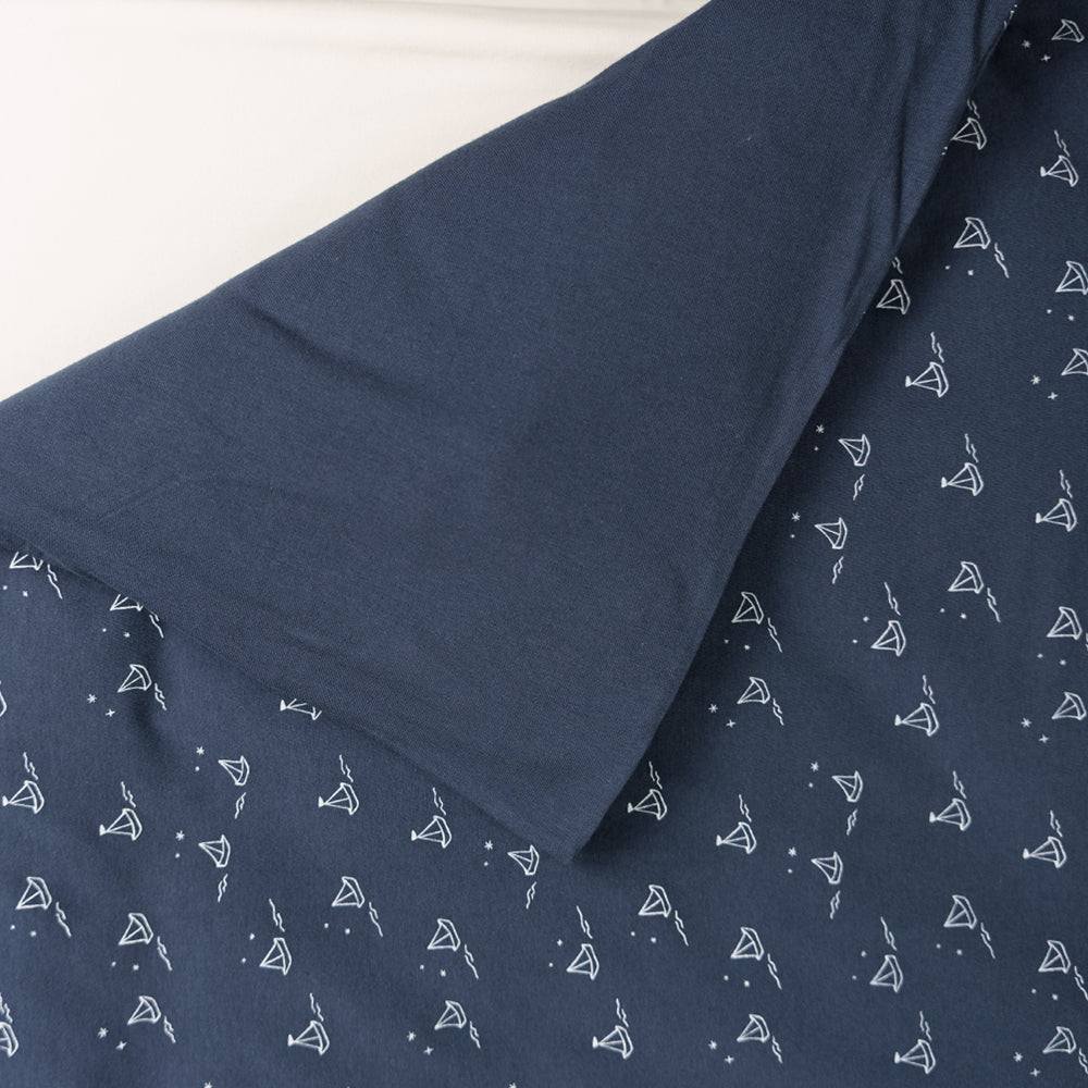Cotton duvet cover with a navy background and all over sailboat print on one side and solid navy colour on the other side. 