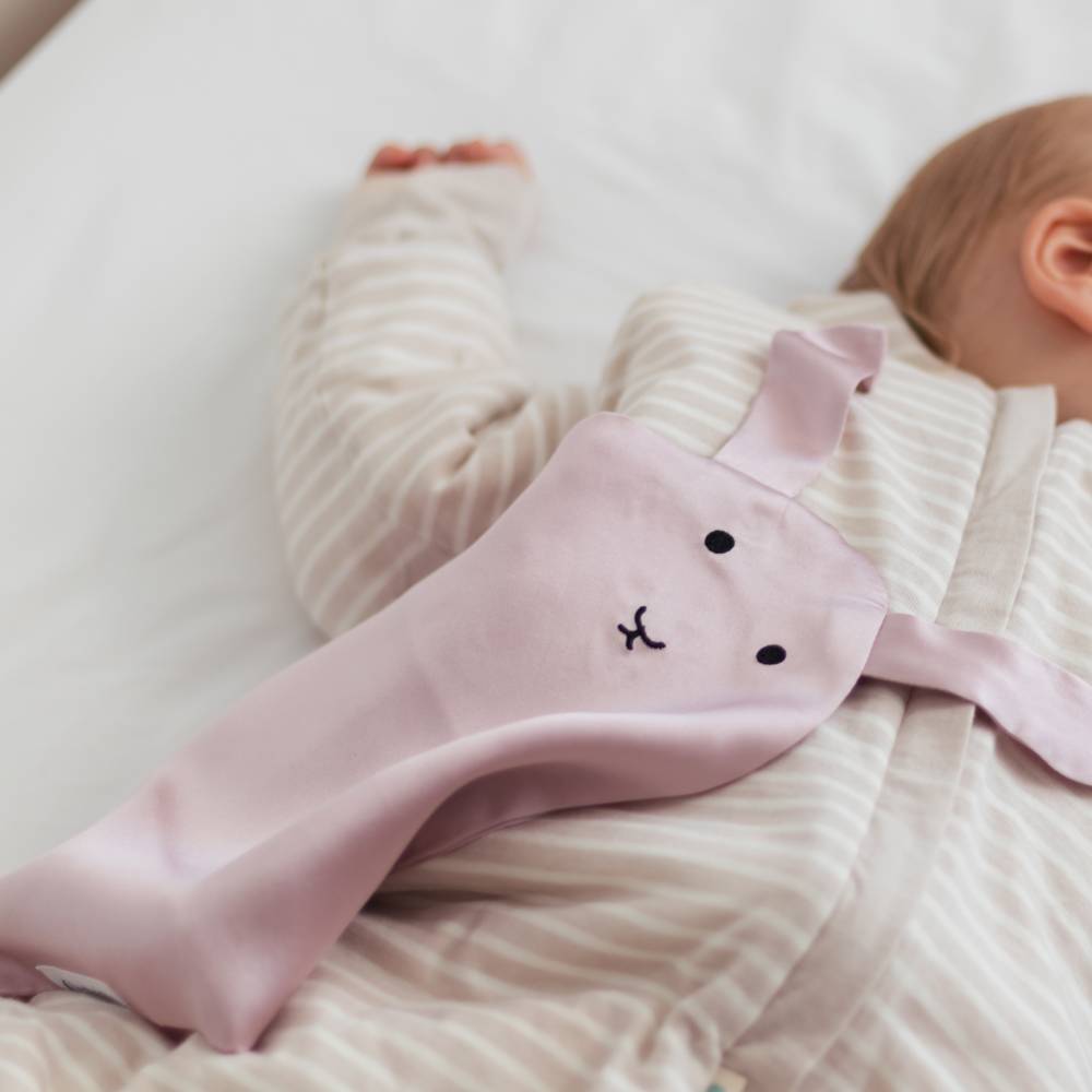 Silk bunny comforter with sleeping child.