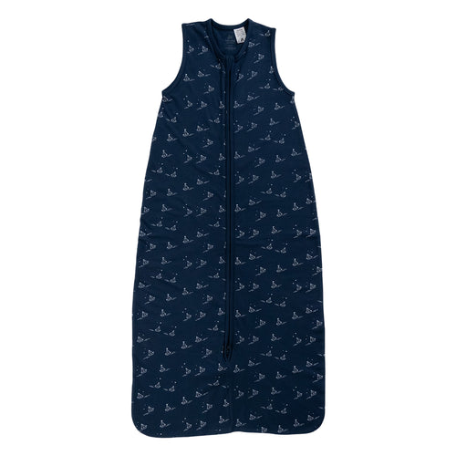 A sleeveless cotton baby sleep sack with sailboats on a navy background, shown flat against a white background.