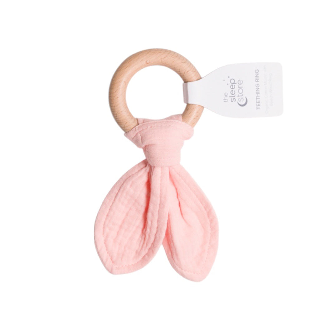 Pink cotton muslin baby teething ring with wooden handle on a white background