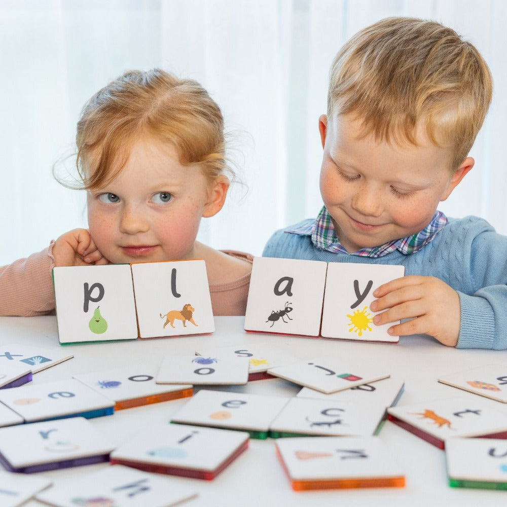 2 children playing with lowercase alphabet tile tek toppers. 