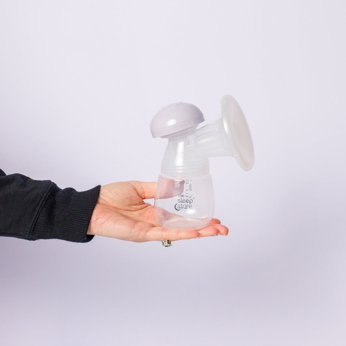 Hand holding a breast pump against a white background