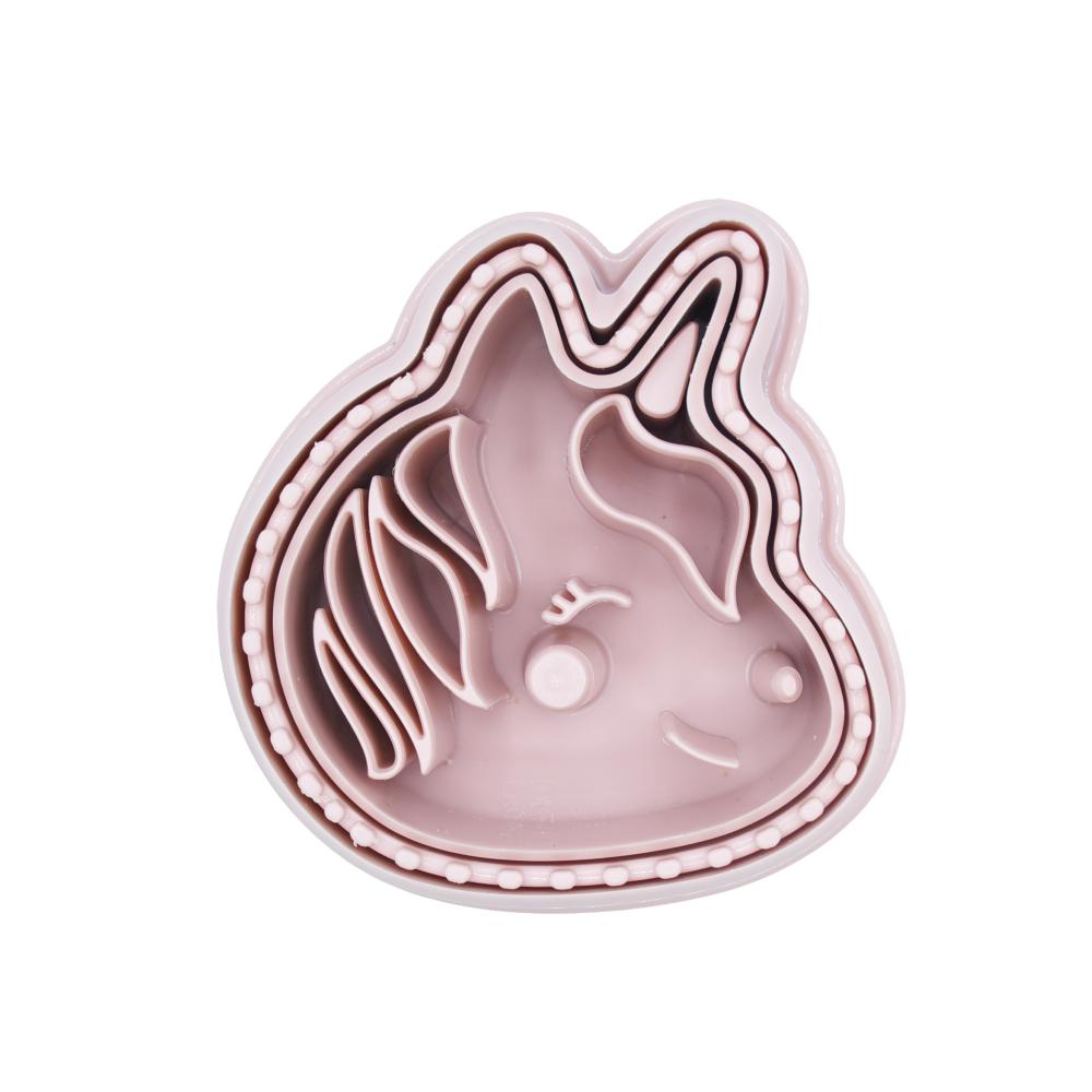 Pink cookie cutter shaped like a unicorn on a white background