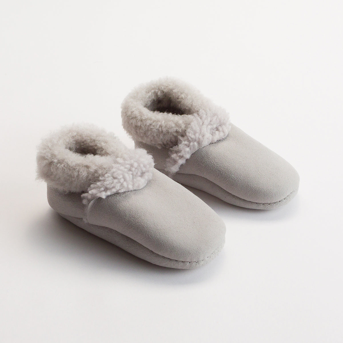 Pair of gray slippers with fuzzy trim on a white background
