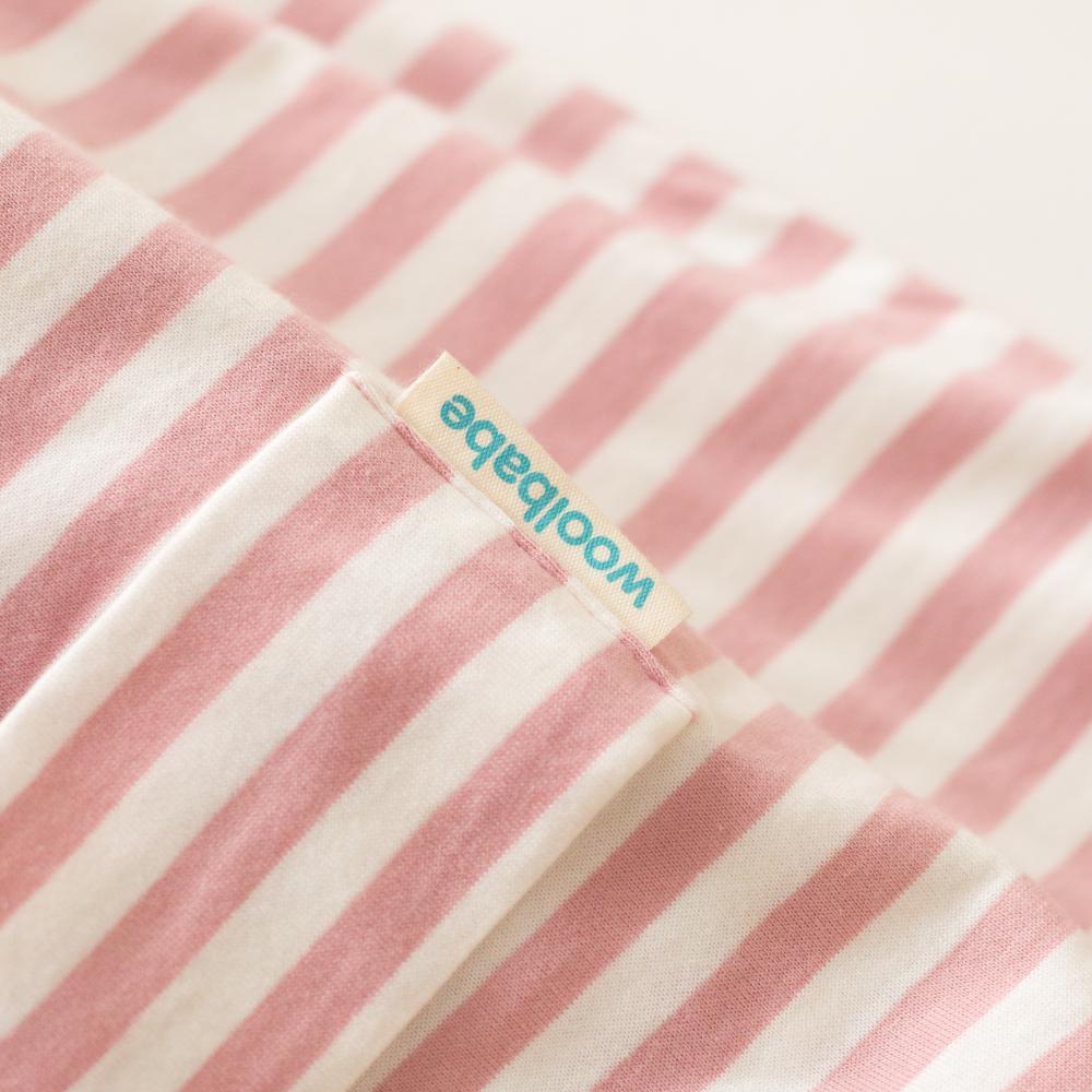Close-up of pink and white striped fabric with a Woolabe label.