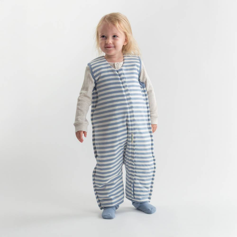 Child wearing a blue and white striped sleep onesie on a plain background