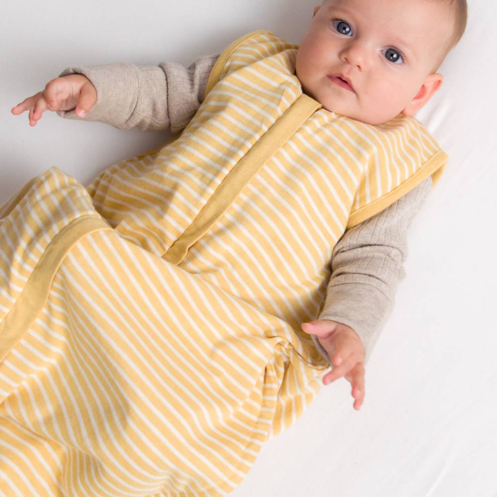 Baby wearing a yellow and white striped outfit on a white background