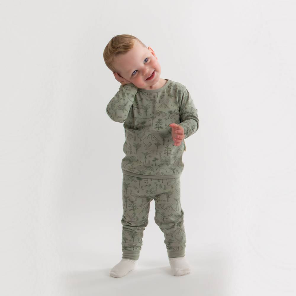 Child wearing a green patterned outfit on a white background