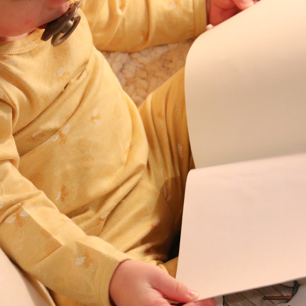 Person wearing a yellow outfit holding a white object.